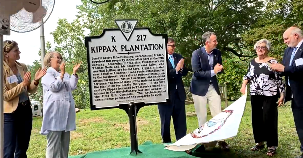 Group of people surrounding sign declaring the site to be Kippax Plantation