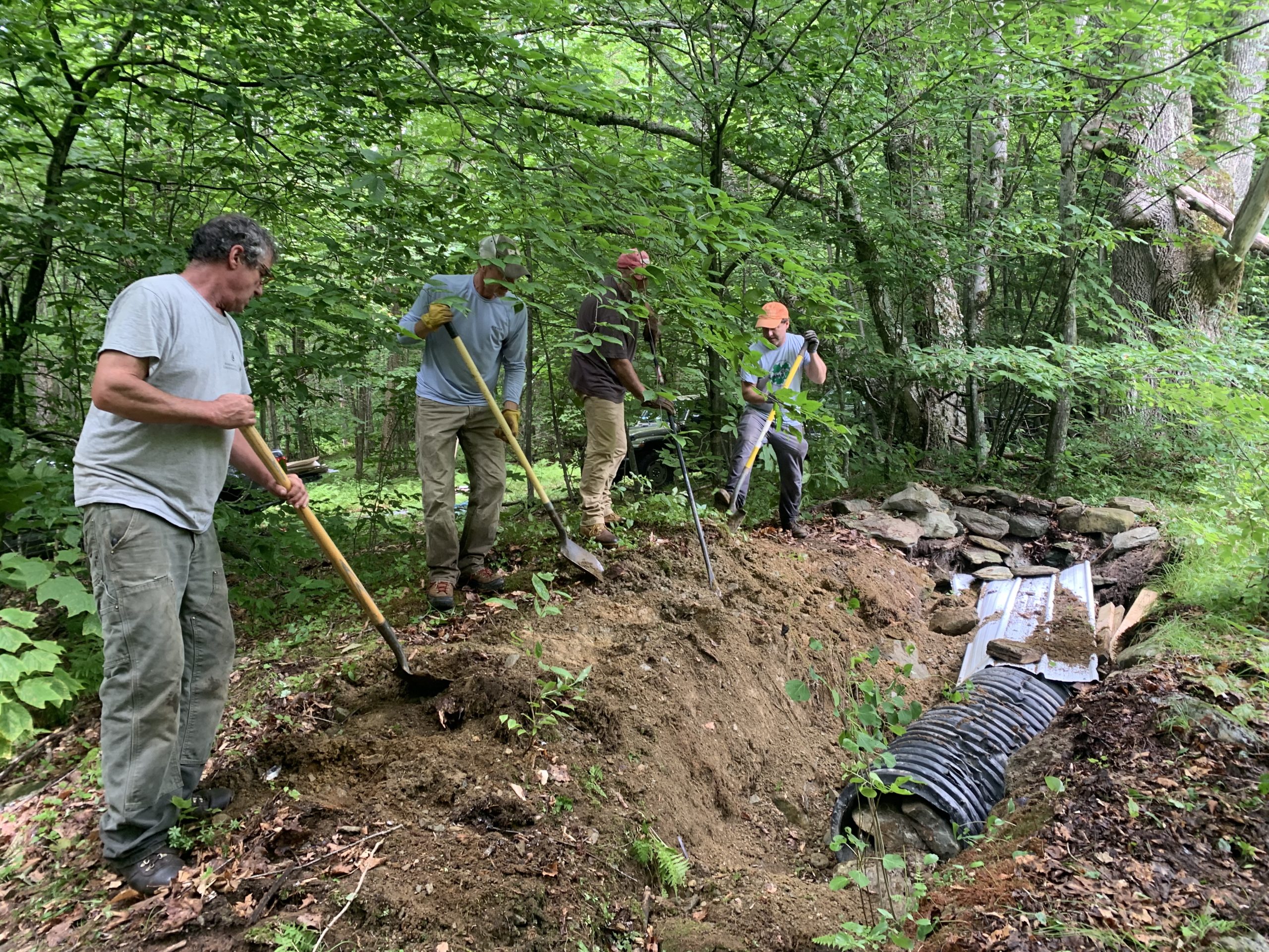 Egg Mountain Preserve stewards Jim Henderson, Stephen Butz, Jack Blandford, and Dave Mance work to backfill the site.