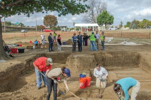 Kary Stackelbeck (center, left) briefs then-Tulsa Mayor G. T. Bynum (center, right) during a site visit on Nov. 3, 2022, with project researchers, City representatives, and other community members while excavations by Stantec archaeologists (foreground) were ongoing. Photo courtesy of the City of Tulsa.